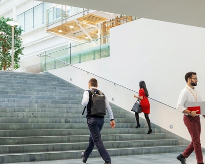 Merdivenlerde yukarı ve aşağı yönde ilerleyen insanlar, birbiriyle konuşan bir kadın ve erkek